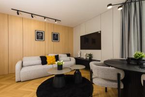 a living room with a couch and a table at Apartamenty Baltic Horst Basen & Restauracja in Niechorze