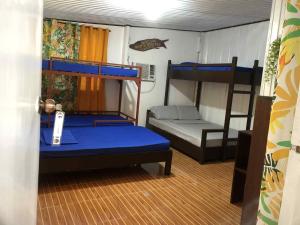 a room with two bunk beds and a room with a bed at Casetta Homestay Siargao in General Luna