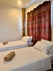a room with two beds and a curtain at Ohana Trining in General Luna