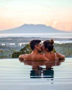 a man and a woman kissing in the water at Sumberkima Resort in Pemuteran