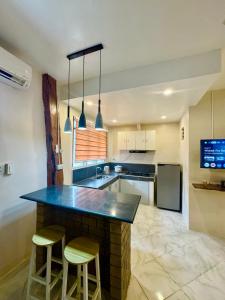 a kitchen with a large counter with two stools at Ohana Trining in General Luna