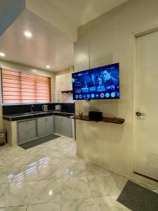 a kitchen with a flat screen tv on the wall at Ohana Trining in General Luna +11 photos