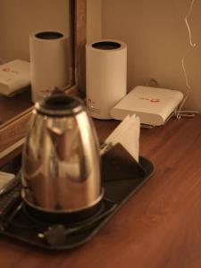 a tea kettle on a plate on a wooden table at Royal Inn in Mysore
