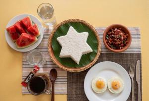 a table topped with plates of food with eggs and fruit at Tree Avenue Villa Dambulla in Galewela