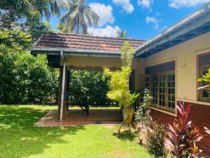 a house with a porch with a roof at Tree Avenue Villa Dambulla in Galewela
