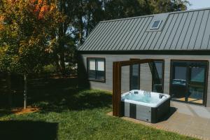 a bath tub sitting in the yard next to a house at The Mist, Luxury Farm w Fireplace & Hot tub in Exeter