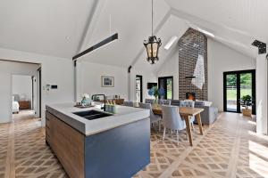 an open kitchen and living room with a table and a dining room at The Mist, Luxury Farm w Fireplace & Hot tub in Exeter