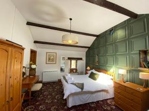 a bedroom with a large bed and a desk at Swaledale Watch Garden Annexe in Wigton