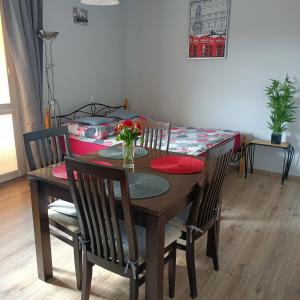 a dining room table and chairs with a table and a bed at Apart Bella in Uniejow +4 photos