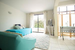 a living room with a blue couch and a tv at Amplia casa en Reñaca para 10 personas in Viña del Mar
