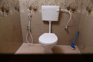 a bathroom with a toilet with a hose at BlueMoon Homestay - Near to Falls and View Points, Home Food & Estate in Sakleshpur +10 photos