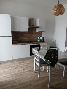 a kitchen with a table and chairs and a refrigerator at APPARTAMENTO JLENIA in Cisterna di Latina +14 photos