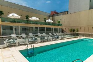 a swimming pool with tables and chairs on a building at Dazzler by Wyndham Buenos Aires Recoleta in Buenos Aires