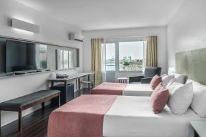 a hotel room with two beds and a flat screen tv at Dazzler by Wyndham Buenos Aires Recoleta in Buenos Aires