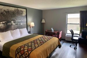a hotel room with a bed and a desk and a window at Super 8 by Wyndham Chenoa in Chenoa +33 photos