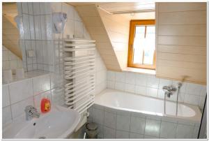 a small bathroom with a tub and a sink at Pension Teichschänke in Zwönitz +13 photos