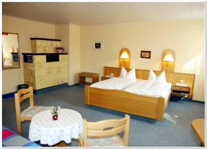 a hotel room with a bed and a table at Pension Teichschänke in Zwönitz