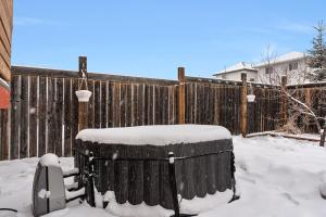 a wooden fence with snow on top of a barrel at 5BR Wild Rose- Meadows, AC, Garage, Sleeps 12 in Edmonton