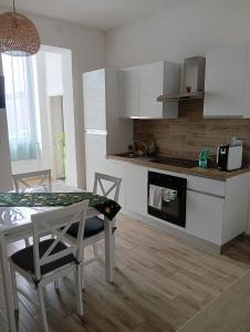 a kitchen with a table and chairs in a room at APPARTAMENTO JLENIA in Cisterna di Latina