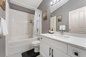a white bathroom with a sink and a toilet at 5BR Wild Rose- Meadows, AC, Garage, Sleeps 12 in Edmonton +35 photos