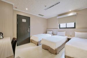 a hotel room with two beds and a window at Golden Stone Hotel in Kaohsiung