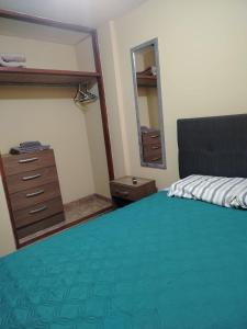 a bedroom with a bed and a dresser and a mirror at Acogedora habitación in Trujillo +8 photos