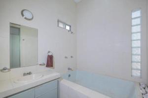 a white bathroom with a sink and a bath tub at Quinta las flores de Elizondo in Xochitepec