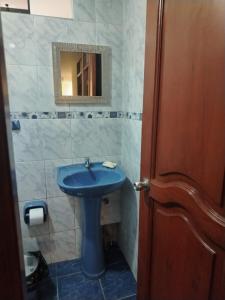 a bathroom with a blue sink and a mirror at Acogedora habitación in Trujillo
