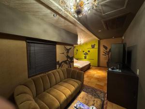 a living room with a couch and a television at ライオンズロック in Nerima