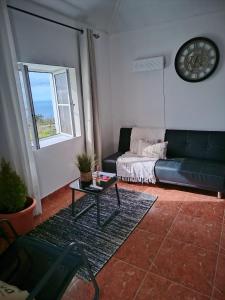 a living room with a couch and a table at Bougainvillea House in Ponta do Pargo