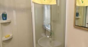 a shower with a glass door in a bathroom at Sunflower Retreat in Cresswell +15 photos