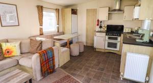 a living room with a couch and a kitchen at Sunflower Retreat in Cresswell