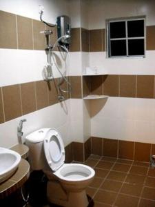 a bathroom with a toilet and a shower at Lacy's Crown Imperial Court Apartment in Cameron Highlands