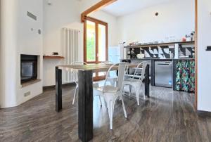 a kitchen with a wooden table and white chairs at Villa Arianna Lake View Apartments with Pool in Tignale