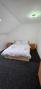 a bed with white sheets and pillows in a room at Pensiune Urban in Borsec
