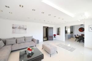 a white living room with a couch and a table at Zotina Residence in Tivat