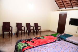 a room with a group of chairs and a bed at BlueMoon Homestay - Near to Falls and View Points, Home Food & Estate in Sakleshpur