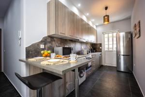 a kitchen with wooden cabinets and a counter with fruits on it at Athenean Sea Breeze in Vari +13 photos