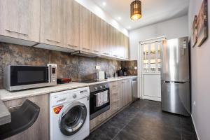 a kitchen with a washing machine and a refrigerator at Athenean Sea Breeze in Vari