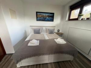 a bedroom with a large bed with two towels on it at Ferienwohnung Plaue Auszeit mit Privatstrand und Bootsliegeplatz in Zislow