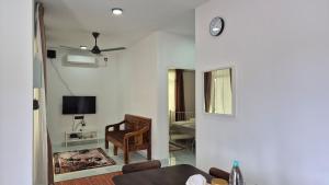 a living room with a couch and a clock on the wall at Ilham Penarek Pantai Penarik in Pulau Che Selamah