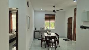 a kitchen and dining room with a table and chairs at Ilham Penarek Pantai Penarik in Pulau Che Selamah