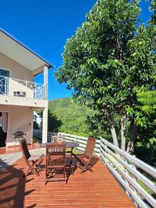 a deck with a table and chairs and a tree at Villa Dijoux D'O in Entre-Deux