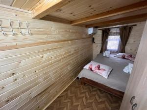a bedroom in a log cabin with a bed in it at Cabana Paltini in Costeşti +91 photos