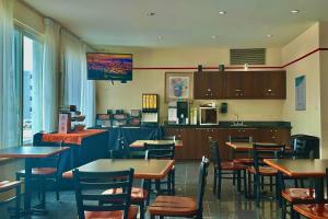a restaurant with tables and chairs and a kitchen at Econo Lodge City Centre in Kingston
