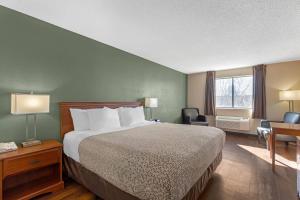 a hotel room with a bed and a desk and a window at Econo Lodge Longmont East in Longmont +43 photos