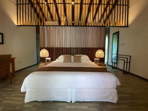 a bedroom with a large bed and two lamps at BuBu Villa in Perhentian Islands