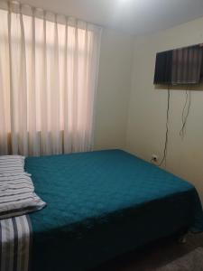 a bedroom with a bed and a window with curtains at Acogedora habitación in Trujillo