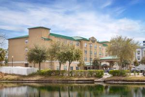 a large building with a lake in front of it at Country Inn & Suites by Radisson, Jacksonville West, FL in Jacksonville