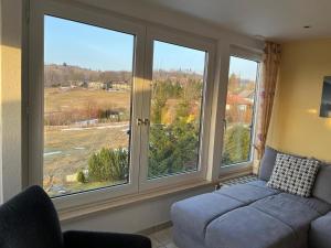a living room with large windows and a couch at Haus Panorama Sankt Andreasberg in Sankt Andreasberg